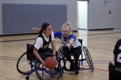 Two people playing wheelchair basketball
